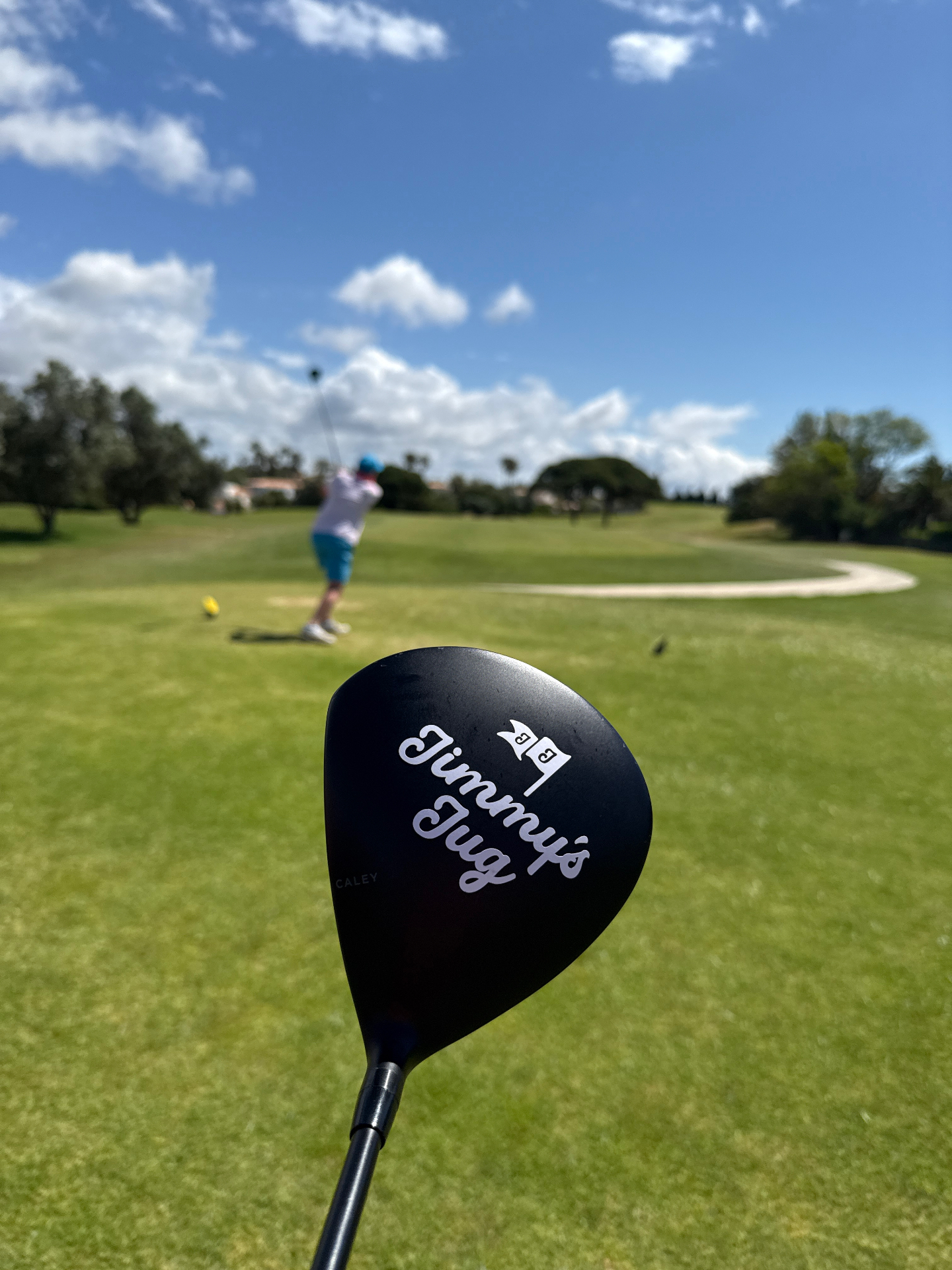 Jimmy's Jug branded driver framing a player on the tee box
